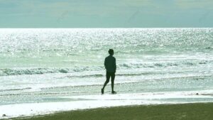437486bc180249b3ca51da5fb870ce7b pngtree backlight real shot of a man walking on the beach image 837