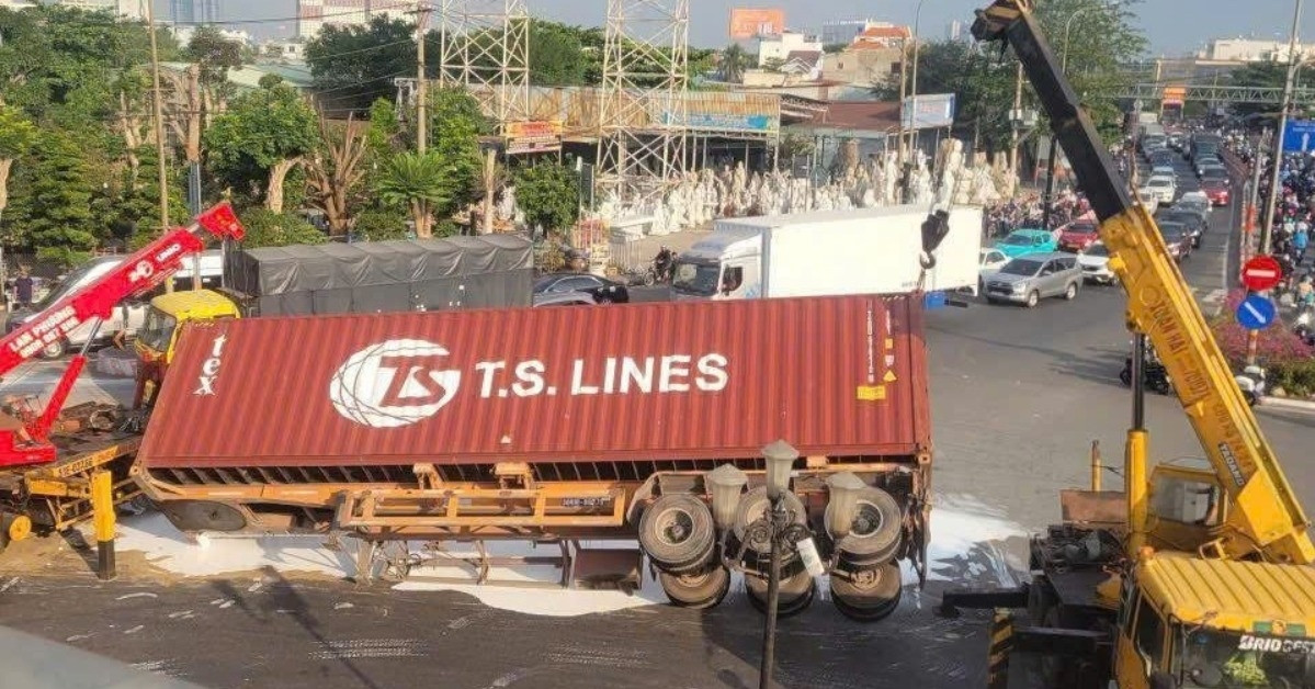 xe container lat ngang giua vong xoay tu than son nuoc nhuom trang mat duong 875